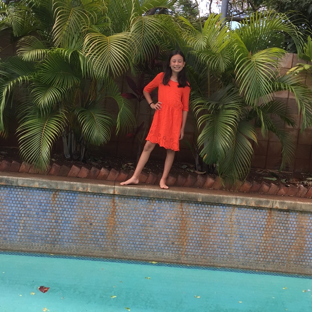 An orange coral colored dress with sleeves.